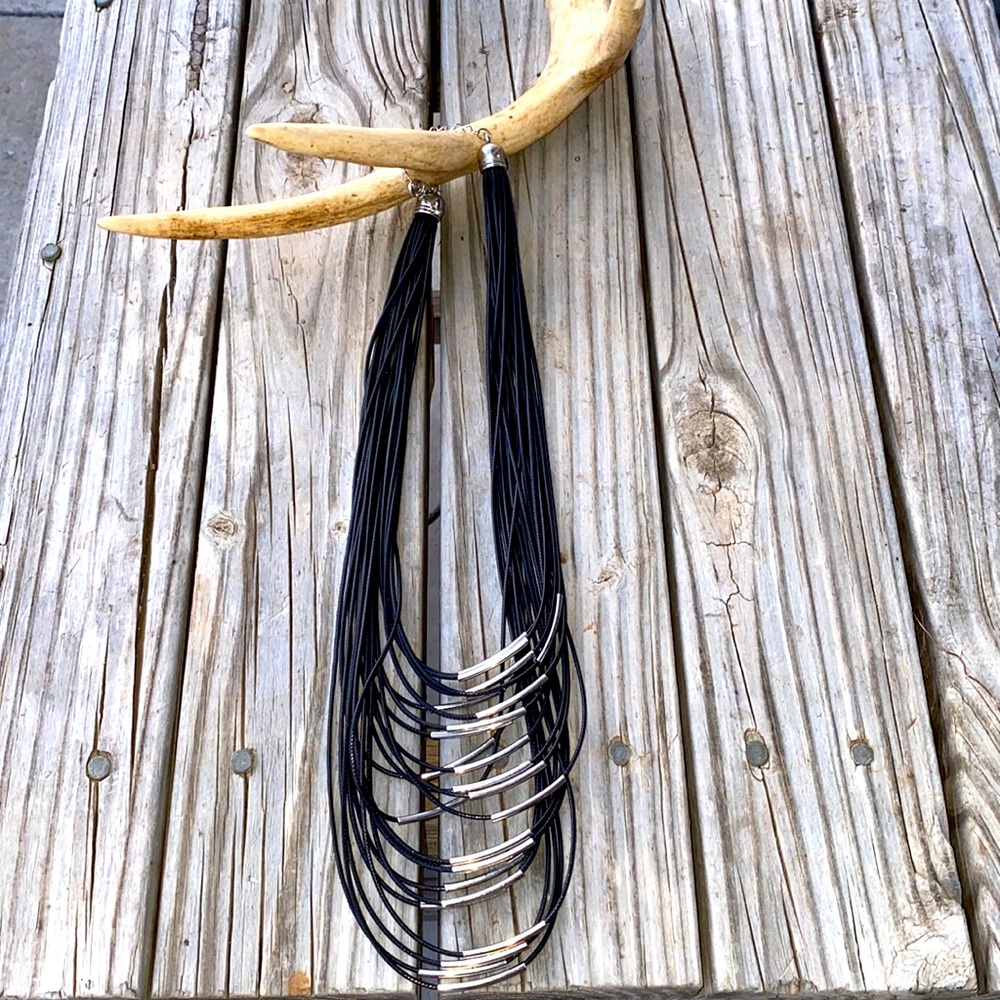 Black multi strand faux leather necklace with silver accents.